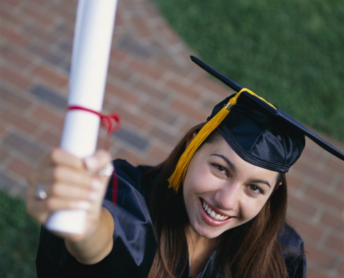 Smiling Graduate Holding up Diploma